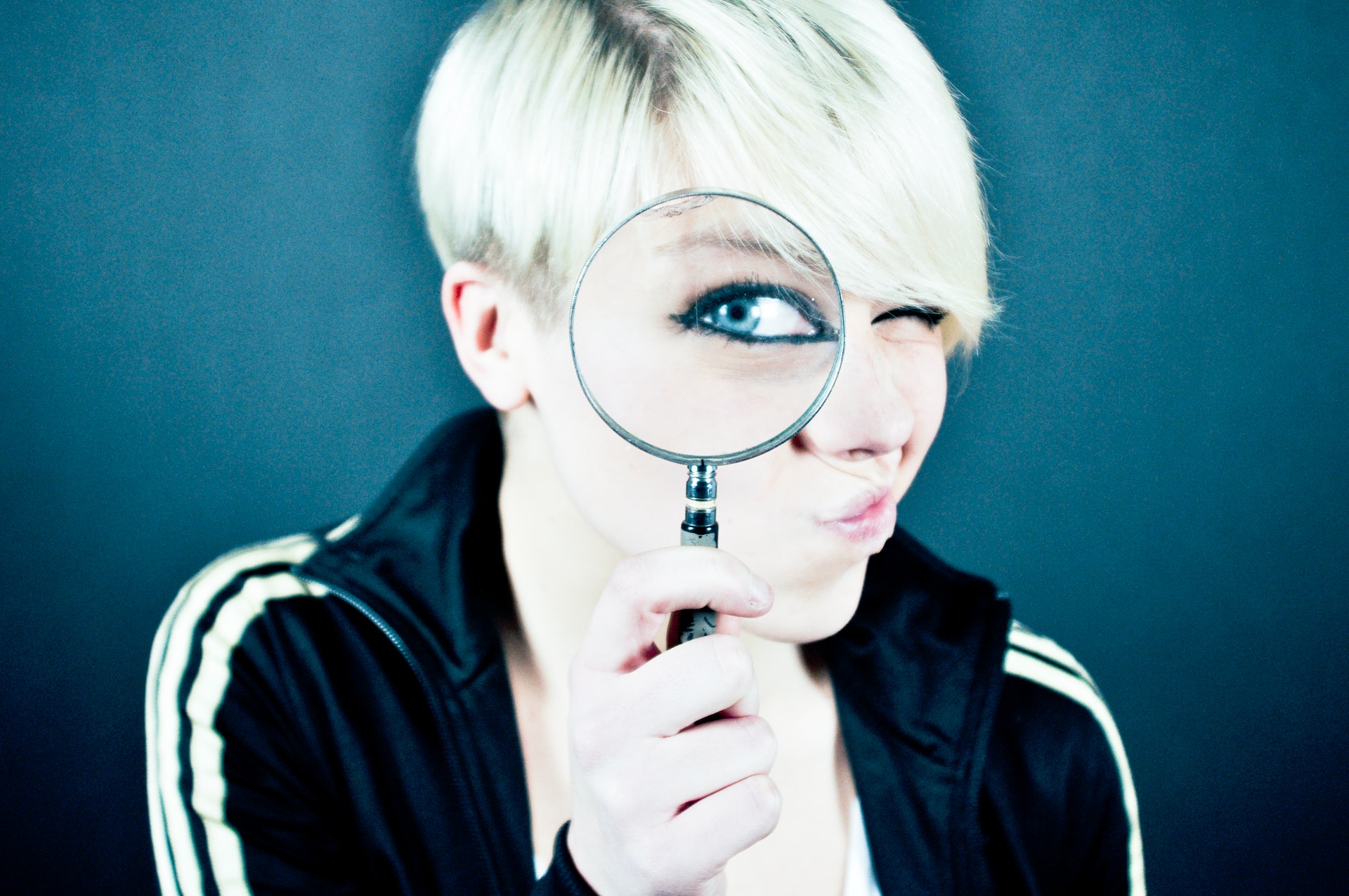 Image shows a lady looking through a magnifying glass, as if she is looking for her IngramSpark sales.