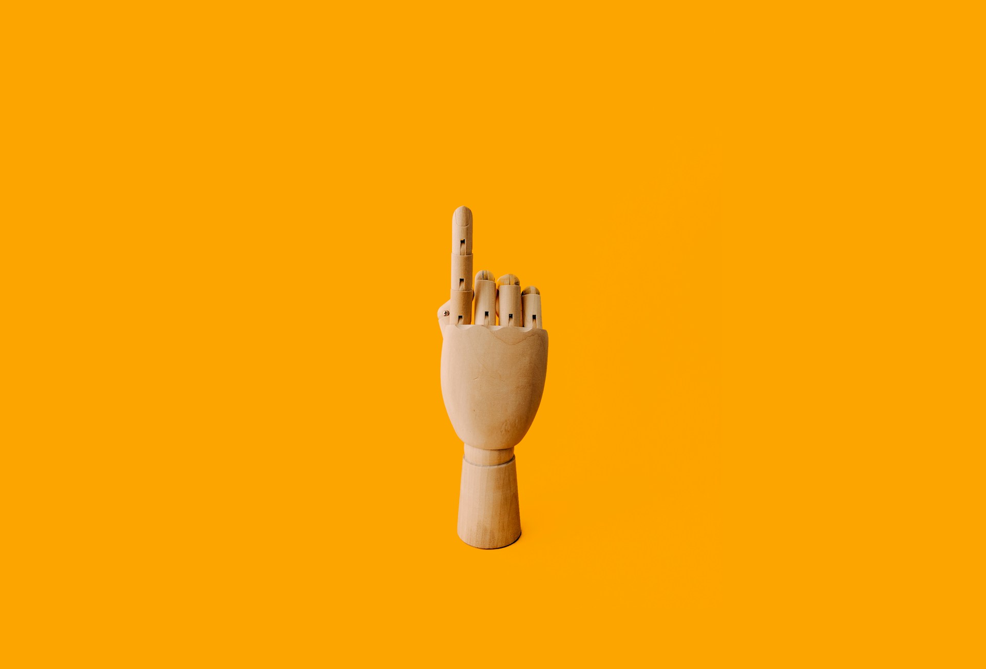 Wooden hand holding up one finger to visualize that one book version can help self-published authors' books reach Amazon best-seller status.